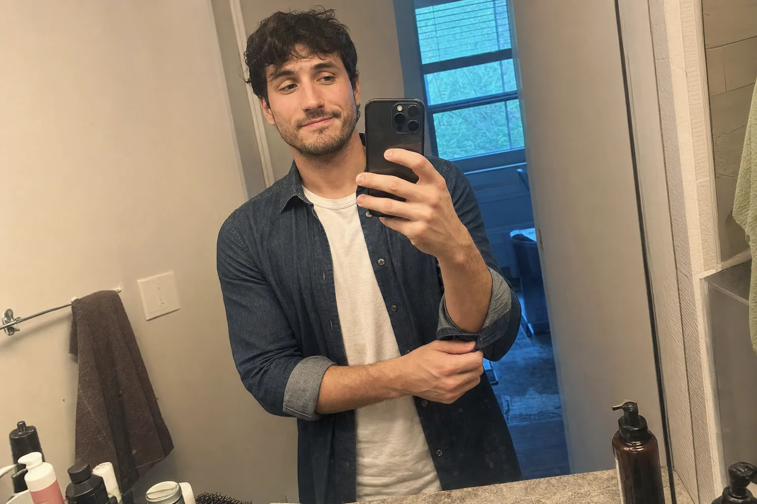 A man takes a slightly nervous mirror selfie while getting ready for a first date.